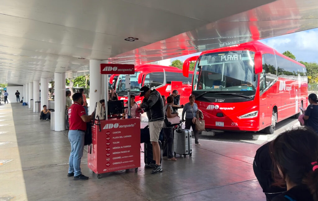 tourists at ticket counter at ADO Bus terminal at Cancun Airport